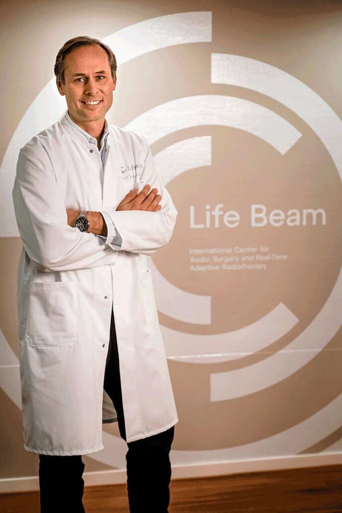 Prof. Dr. med. Hendrik Wolff vor dem Life Beam Logo
